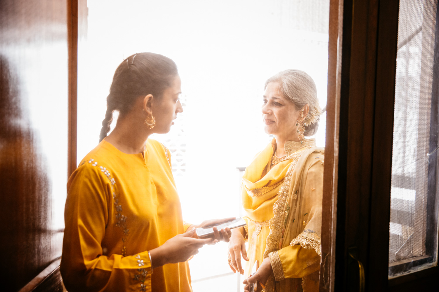 Two women in yellow at doorway