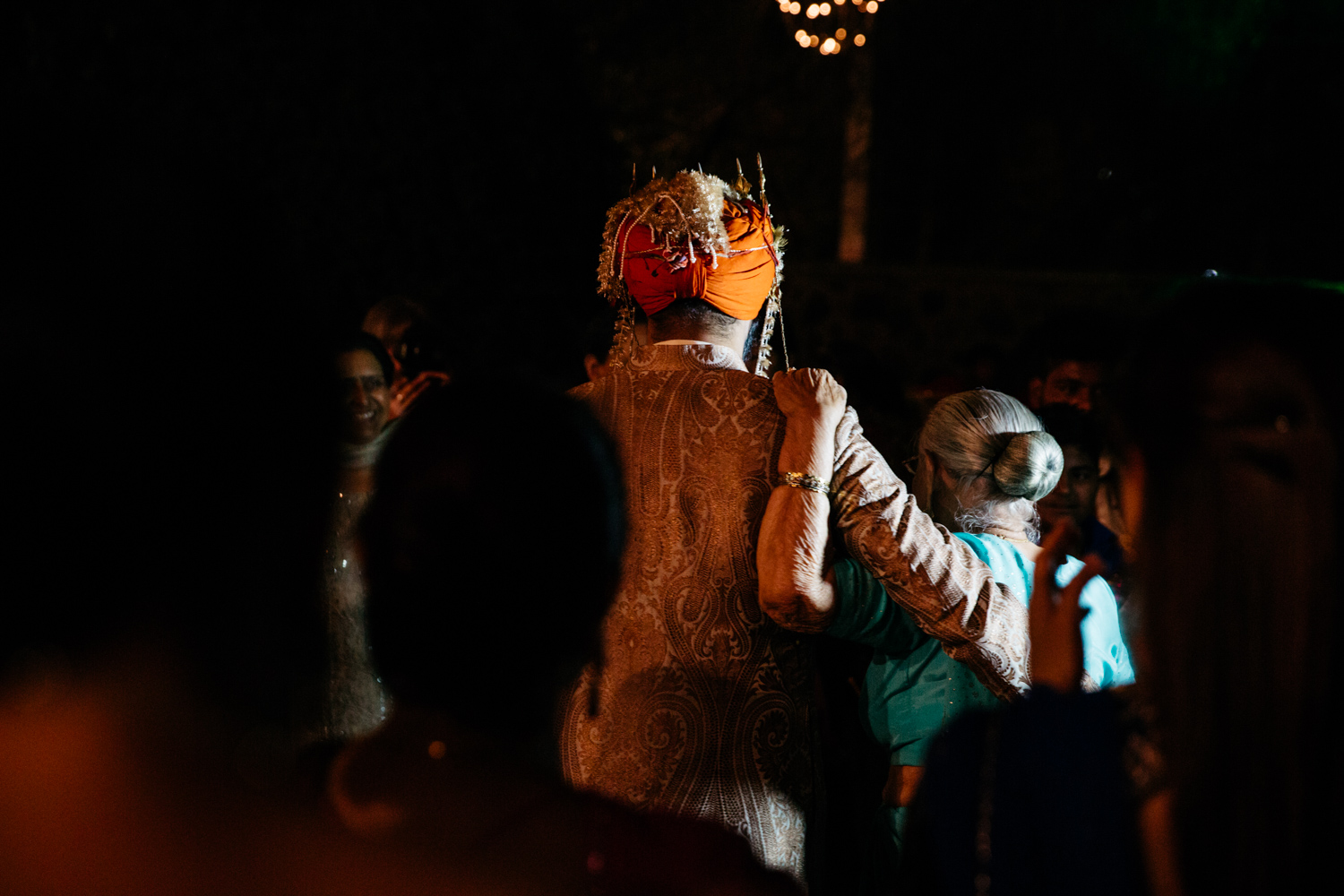 Grandmother leading groom — backs to camera