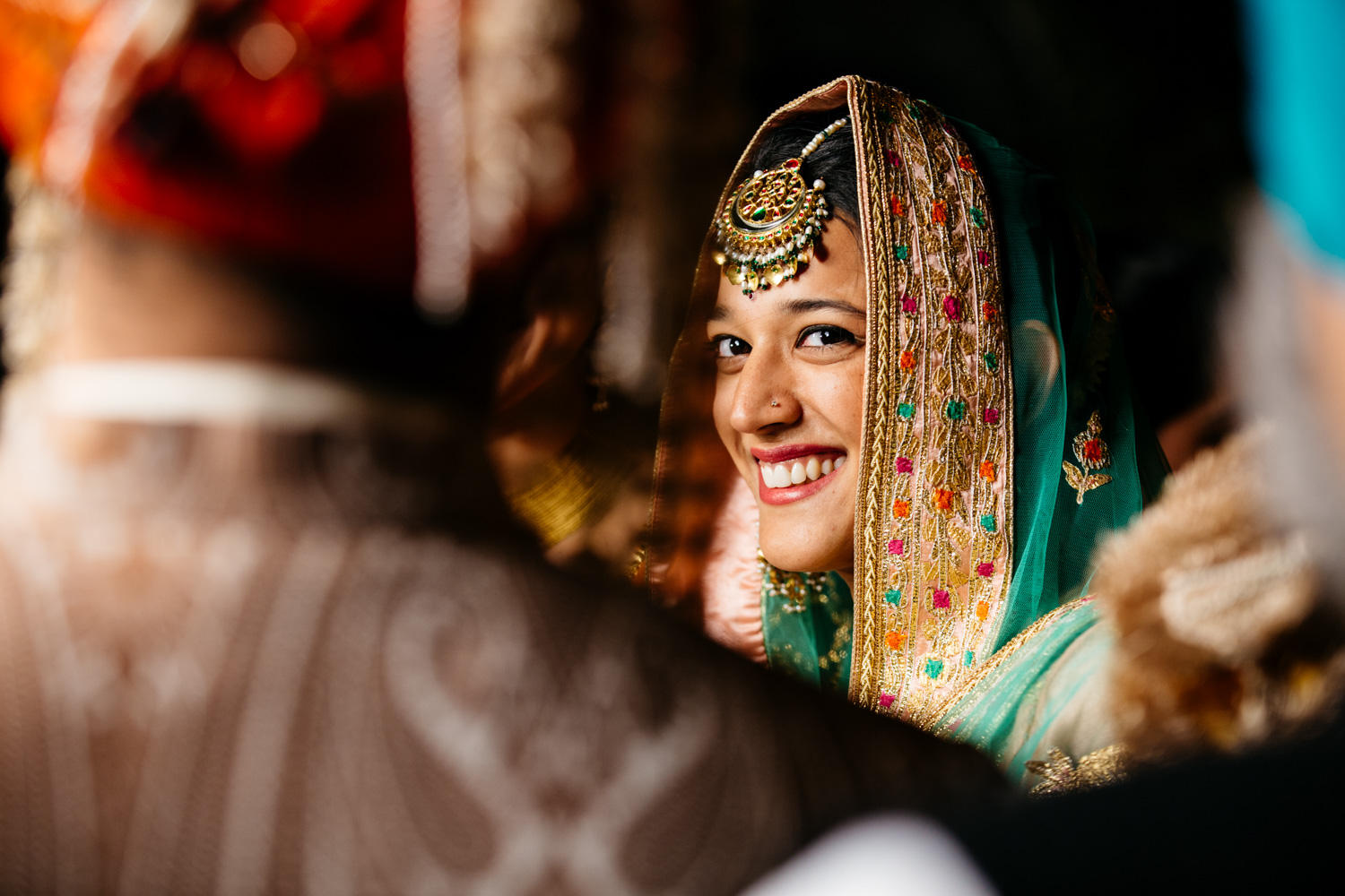 Bride smiling under veil — charming