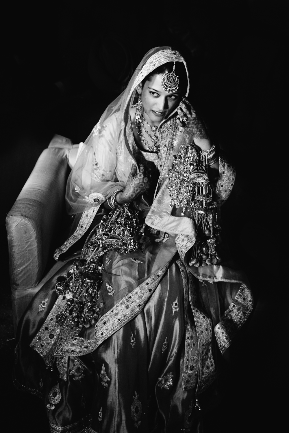 B&W bride sitting in lehenga — reflective