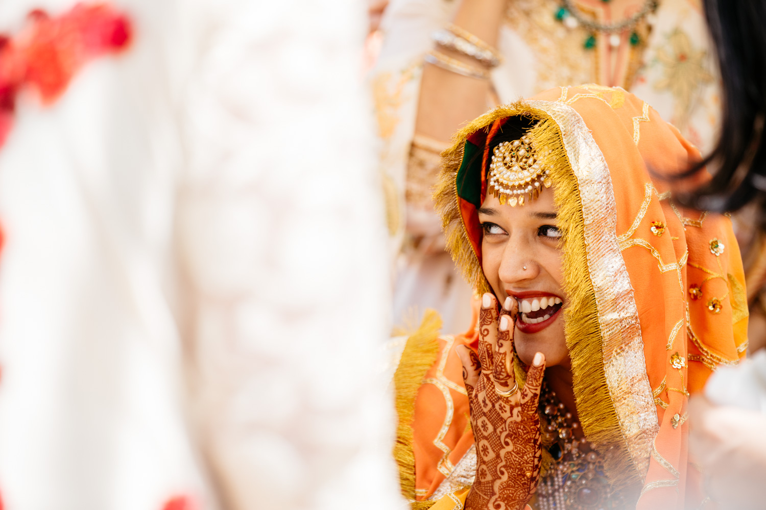 Bride laughing with mehndi hands — bashful