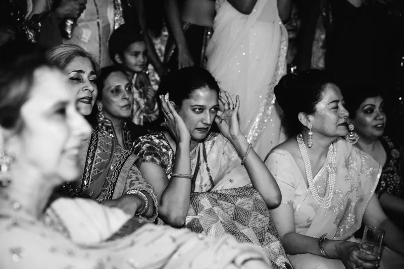 Woman covering ears in crowd — B&W