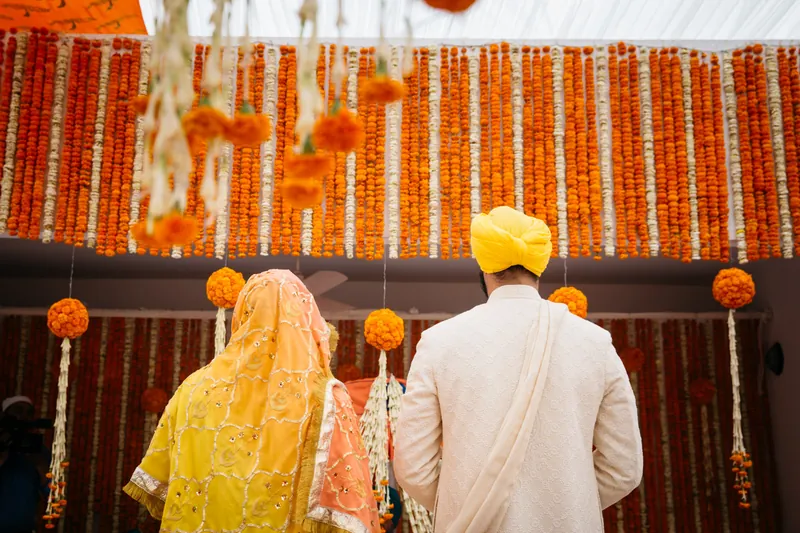 Couple facing wall of marigolds
