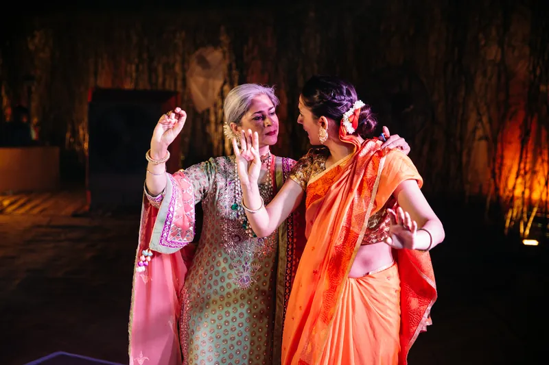 Two women dancing in warm light