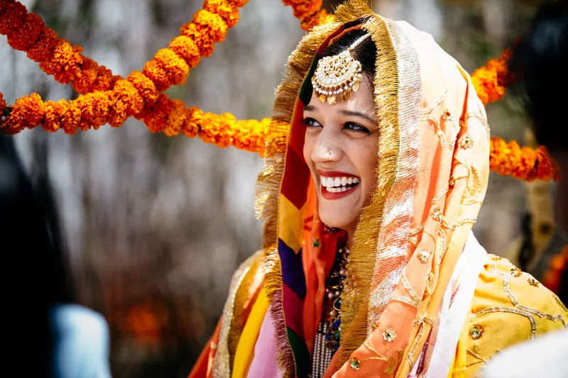 Bride laughing under orange veil — radiant